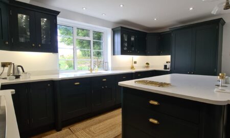 Sprayed olive green kitchen cabinets with brass handles, completed by Lord Hart Decorating Services, featuring a smooth, flawless finish and modern worktop in a contemporary home setting.